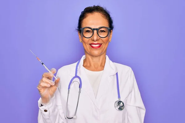 中年シニア専門医女性保持注射器で医療ワクチン幸せな顔立ちと笑顔で自信を持って笑顔示す歯 — ストック写真