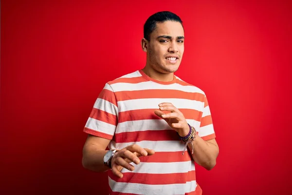 Jovem Brasileiro Vestindo Camiseta Listrada Casual Sobre Fundo Vermelho Isolado — Fotografia de Stock