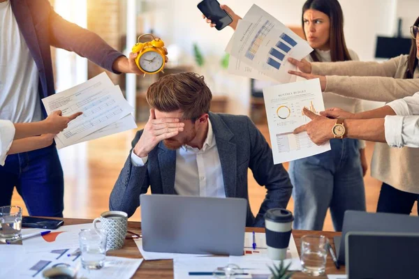 Group of business workers working together. Partners stressing one of them at the office