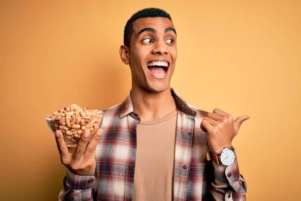 Handsome African American Man Holding Bowl Heathy Peanuts Yellow Background — Stock Photo, Image