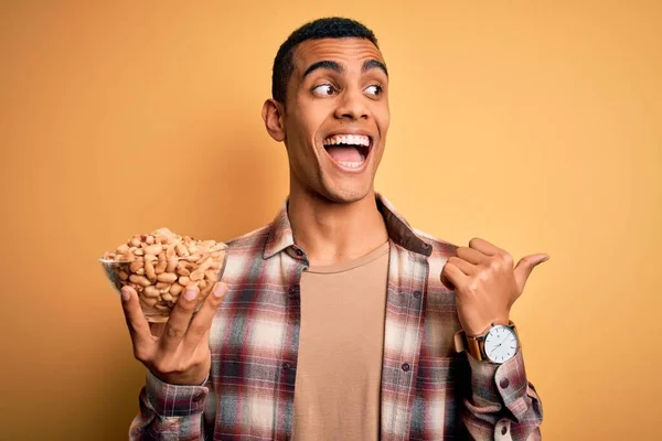 Hombre Afroamericano Guapo Sosteniendo Tazón Con Cacahuetes Paganos Sobre Fondo — Foto de Stock