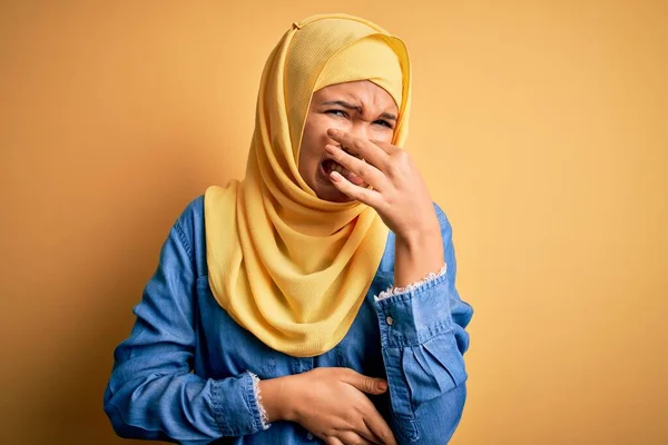 Młoda Piękna Kobieta Kręconymi Włosami Arabskim Hidżabie Żółtym Tle Pachnąca — Zdjęcie stockowe