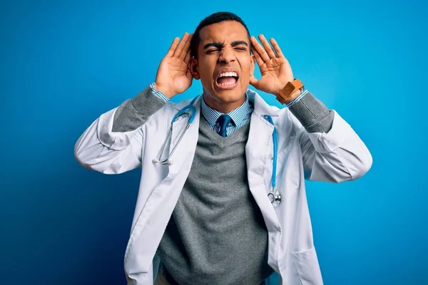 Przystojny Afrykański Lekarz Płaszczu Stetoskopie Niebieskim Tle Próbujący Usłyszeć Obie — Zdjęcie stockowe