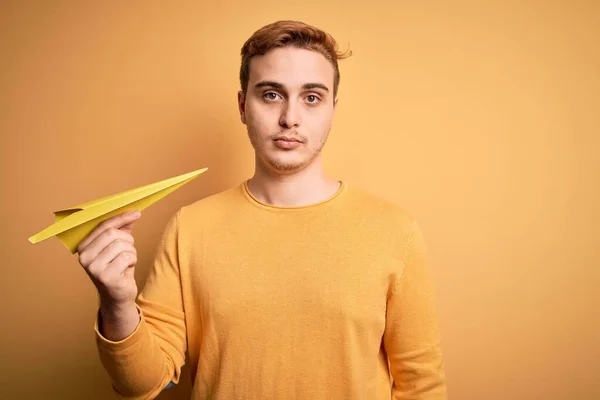 Junge Hübsche Rothaarige Mann Hält Papierflugzeug Über Isolierten Gelben Hintergrund — Stockfoto
