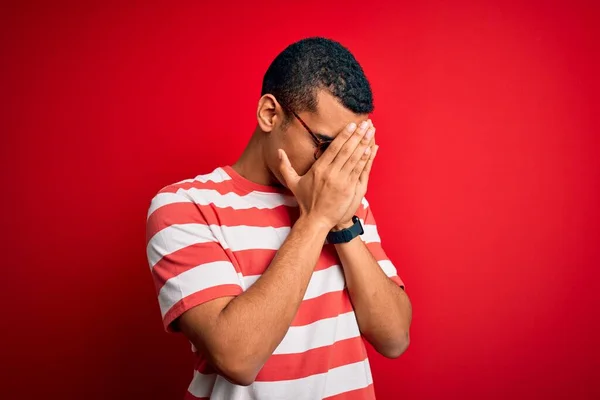 잘생긴 아프리카 미국인 남자가 줄무늬 티셔츠를 눈물을 흘리면서 손으로 얼굴을 — 스톡 사진
