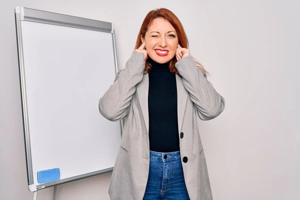 아름다운 사업가가 발표를 시끄러운 소리에 짜증나는 표정으로 판위에 장치를 합니다 — 스톡 사진