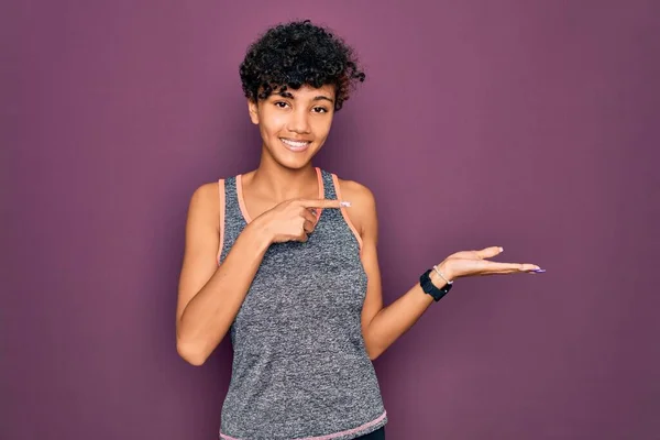 年轻而美丽的非洲裔美国女运动员穿着运动服做运动 一边手拿着手 一边指指指点点地对着摄像机笑着 一边惊讶极了 — 图库照片