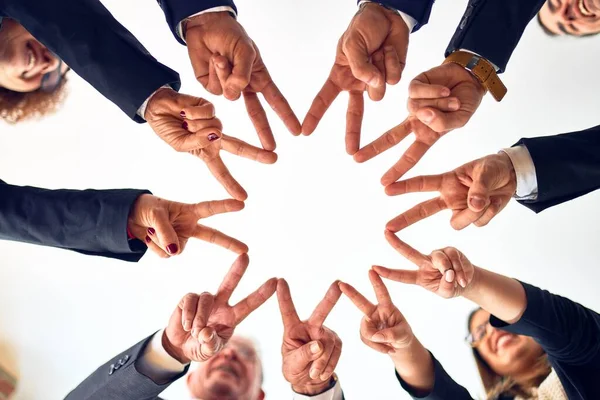 企業の労働者のグループは幸せと自信を笑顔 オフィスで一緒に指で記号を行う顔に笑みを浮かべて円の上に立つ — ストック写真