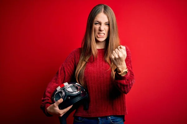 Junge Schöne Rothaarige Motorradfahrerin Mit Motorradhelm Über Rotem Hintergrund Genervt — Stockfoto