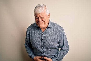 Üst düzey yakışıklı beyaz gömlekli adam midesi bulandığı için izole edilmiş beyaz arka planda duruyor. Ache kavramı.