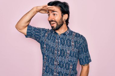 Pembe arka planda hippi tarzı giyinmiş, yakışıklı, bohem bir adam. Çok mutlu ve gülümsüyor. Konsept aranıyor.