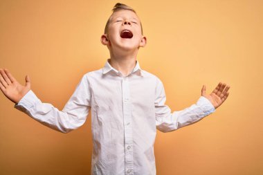 Mavi gözlü, sarı arka planda zarif beyaz gömlek giyen genç beyaz çocuk kollarını kaldırmış ve gözlerini kapatmış heyecanla haykırarak başarıyı kutluyor. Kazanan konsept