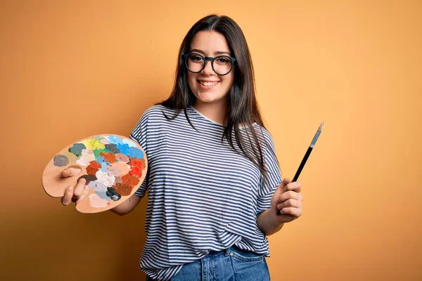 Genç Esmer Kadın Elinde Boya Fırçası Palet Ile Sarı Arka — Stok fotoğraf