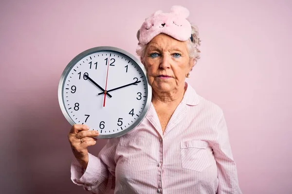 Пожилая Красивая Женщина Маске Сна Держащая Большие Часы Изолированном Розовом — стоковое фото
