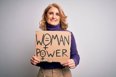 Orta yaşlı güzel sarışın kadın kadın kadın hakları istiyor. Elinde mutlu bir yüzle bayrak var. Kendine güvenen bir gülümsemeyle dişlerini gösteriyor.
