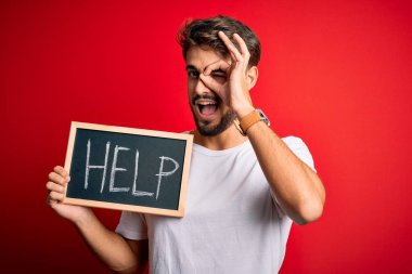 Siyah tahtayı tutmakta zorlanan genç adam kırmızı fırında gülümseyen bir yüzle yardım mesajı yolluyor. Tamam, el ele imzala ve parmaklarından bak.