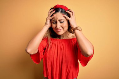 Genç ve güzel bir kadın. Rengarenk bir yaz tarzında. Sarıdan izole edilmiş bir arka plan. Ellerini başının üstüne koy..