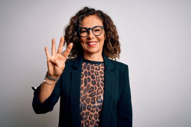 Orta yaşlı esmer iş kadını gözlüklü, izole edilmiş beyaz arka planda duran ve dört numarayı işaret eden kendinden emin ve mutlu bir şekilde gülümseyen..