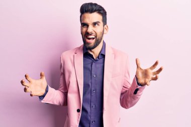 Sakallı, zarif ceketli genç yakışıklı adam deli gibi bağırıyor, agresif bir ifadeyle bağırıyor ve kollarını kaldırıyor. hüsran kavramı. 