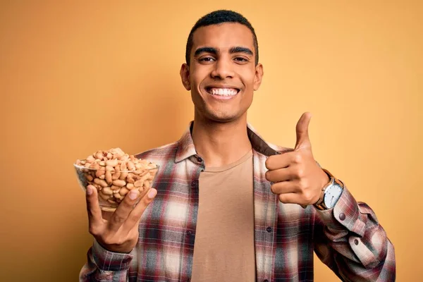 Handsome African American Man Holding Bowl Heathy Peanuts Yellow Background — Stock Photo, Image