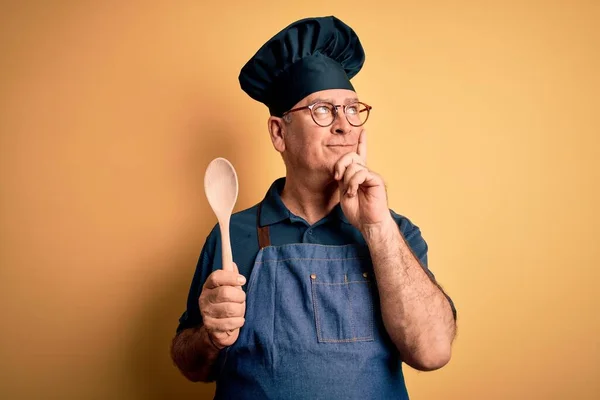 Mann Mittleren Alters Mit Kochschürze Und Hut Kochlöffel Über Gelbem — Stockfoto