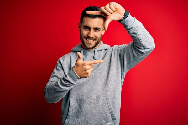 Jovem Desportista Bonito Vestindo Camisola Sobre Fundo Vermelho Isolado Sorrindo — Fotografia de Stock