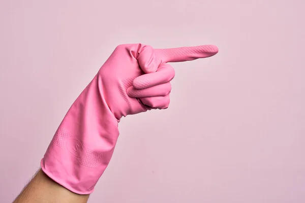 Ręka Białego Młodzieńca Rękawicą Czyszczącą Odizolowanym Różowym Tle Wskazując Palcem — Zdjęcie stockowe