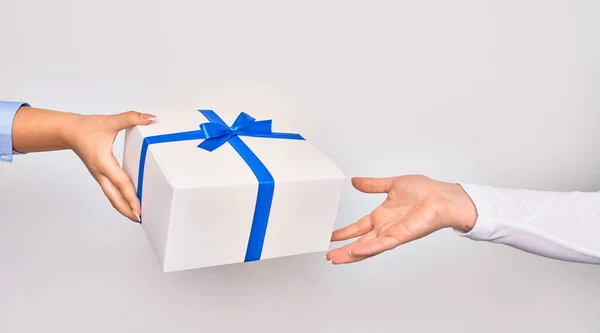 Hand of caucasian young woman giving birthday gift to other person over isolated white background