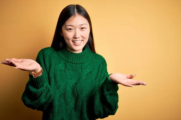 초록빛 스웨터를 노랗게 고립된 위에서 아름답고 아름다운 이시아 여성은 긍정적 — 스톡 사진
