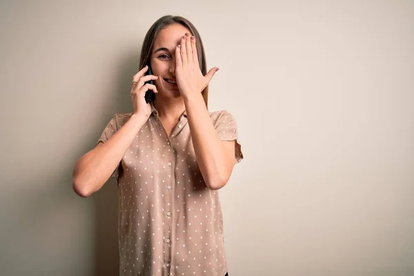 Jovem Mulher Bonita Conversando Smartphone Sobre Fundo Branco Cobrindo Olho — Fotografia de Stock