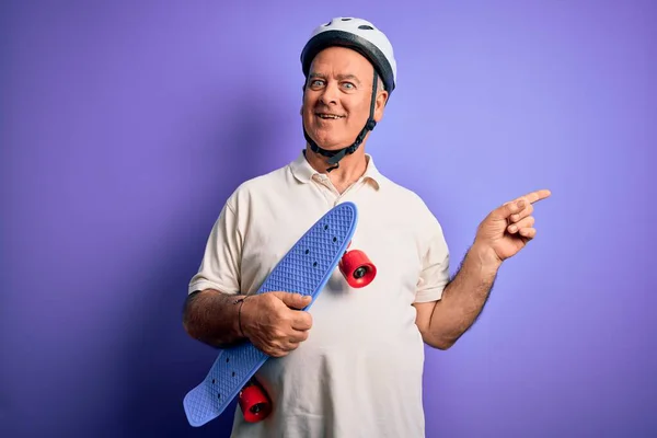 Człowiek Średnim Wieku Hoary Noszenia Kasku Bezpieczeństwa Trzymając Deskorolkę Fioletowym — Zdjęcie stockowe