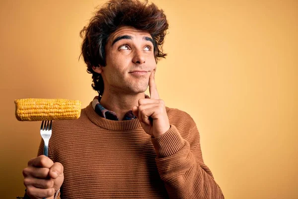 Mladý Pohledný Muž Držící Vidličku Kukuřicí Stojící Nad Izolovaným Žlutým — Stock fotografie
