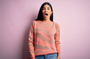 Pembe arka planda hayvan desenli süveter giyen genç, güzel İspanyol moda kadın korku, korku ve heyecan dolu bir yüz ifadesiyle dehşete düşmüş ve şok olmuştu..