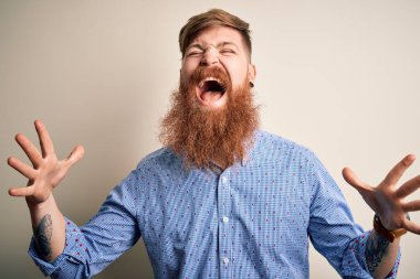 Yakışıklı, kızıl saçlı, sakallı bir iş adamı, izole bir arka planda durmuş, çılgın ve başarıyı kollarını kaldırmış ve gözleri kapalı heyecanla haykırarak kutluyor. Kazanan konsept