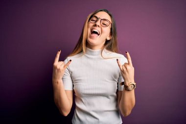 Mavi gözlü, mor arka planda sıradan tişörtler giyen, çılgın bir ifadeyle elleri havada rock sembolü yapan genç, güzel sarışın kadın. Müzik yıldızı. Ağır konsept.