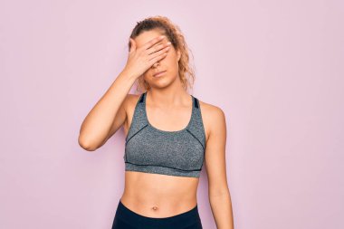 Genç, sarışın, mavi gözlü sporcu kadın spor kıyafetleri giyip gözleri kapatıyordu. Ciddi ve üzgün görünüyordu. Görme, saklama ve reddetme konsepti