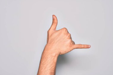 Kafkas genci parmaklarını izole edilmiş beyaz arka planda gösteriyor Hawaii Shaka selamlama hareketi, telefon ve iletişim sembolü.