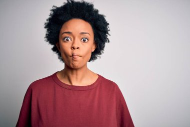 Kıvırcık saçlı, sıradan tişörtlü, dudağıyla balık suratı yapan güzel Afro-Amerikan kadın. Çılgınca ve komik bir hareket. Komik ifade.