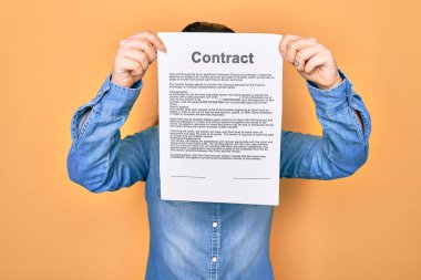 Sözleşme belgelerini tutan kadın izole edilmiş sarı arka planda duruyor.