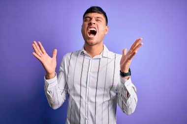 Zarif bir iş gömleği giymiş genç, yakışıklı İspanyol bir adam mor arka planda durmuş, çılgın ve başarıyı kollarını kaldırıp, heyecanla haykırarak kutluyor. Kazanan konsept