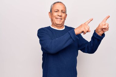 Gri saçlı, sıradan bir süveter giyen, gülümseyen ve kameraya bakan yaşlı bir adam.. 