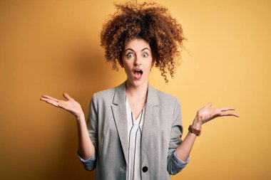 Kıvırcık saçlı ve piercingli genç ve güzel bir iş kadını çılgın ve başarıyı kollarını kaldırıp heyecanla haykırarak kutlayan zarif bir ceket giyiyor. Kazanan konsept