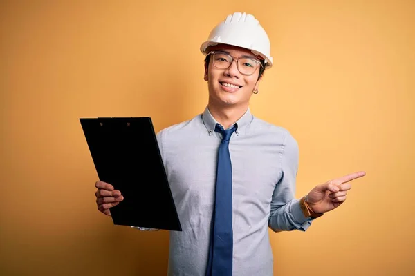 Ung Stilig Kinesisk Ingenjör Man Bär Skyddshjälm Håller Urklipp Mycket — Stockfoto