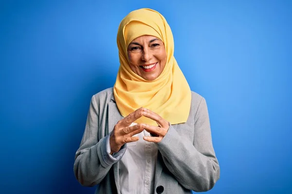青の背景にイスラム教徒の伝統的なヒジャーブを身に着けている中世のブルネットのビジネス女性一緒に手と指はリラックスして陽気に笑顔を交わした 成功と楽観的 — ストック写真