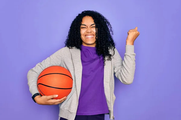 Африканская Кудрявая Женщина Занимающаяся Спортом Держа Баскетбольный Мяч Фиолетовом Фоне — стоковое фото