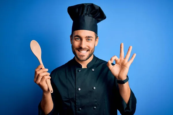 Jovem Homem Fogão Com Barba Vestindo Uniforme Segurando Colher Madeira — Fotografia de Stock