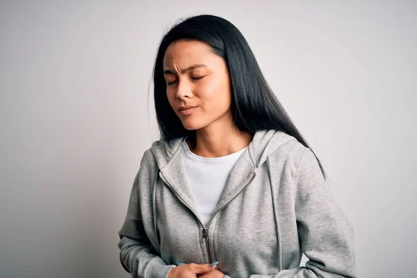 消化不良 痛みを伴う病気が体調不良のため 若い美しい中国のスポーティな女性は胃の上に手で隔離された白い背景にスウェットシャツを着て アチェの概念 — ストック写真