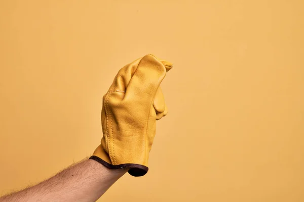Mão Homem Jovem Caucasiano Com Luva Jardineiro Sobre Fundo Amarelo — Fotografia de Stock