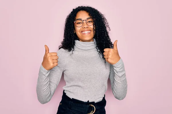 Młoda Afroamerykanka Ubrana Sweter Okulary Różowym Tle Znak Sukcesu Robi — Zdjęcie stockowe