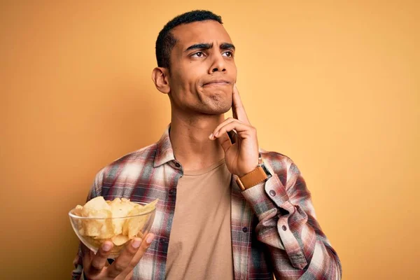 Jóvenes Afriamericanos Guapo Teniendo Tazón Patatas Chips Sobre Fondo Amarillo — Foto de Stock